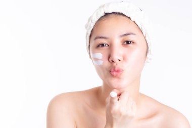 Genç kadın kremi, yüzüne nemlendirici sür. Asyalı kadın krem sürüyor, güzel cildine losyon sürüyor, gülümsüyor. Asyalı güzel kız mutluluğu hak ediyor. Onun güzel bir teni var. Cilt bakımı kavramı, telif alanı