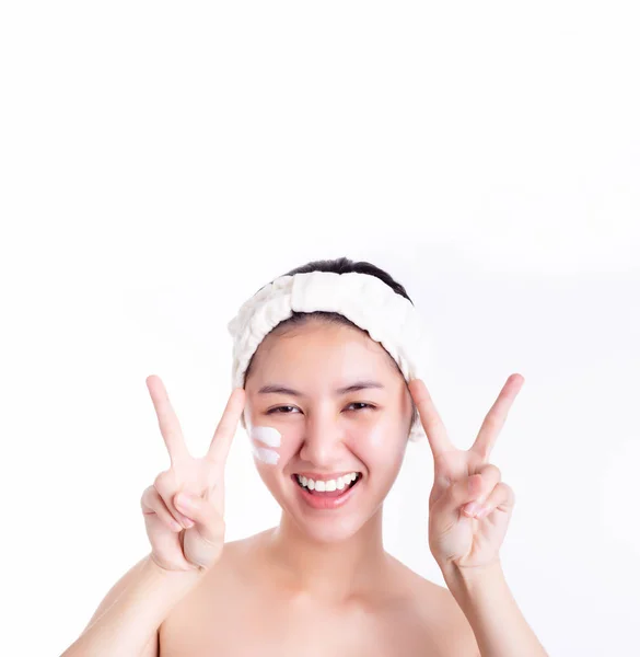 迷人的漂亮女人有漂亮的脸蛋 复制空间 亚洲女人洗完澡后在脸上涂上乳膏和乳液 漂亮的亚洲姑娘用手指做V的符号来表示胜利 — 图库照片