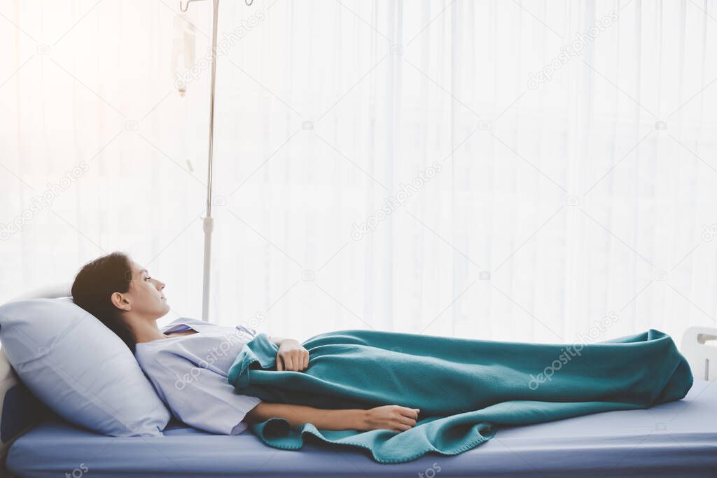 Patient person sleep on patient bed in hospital room. Sick woman get high fever. Illness girl get Surveillance or quarantine symptoms in separate patient room. She get tired, weak. Patient stay alone