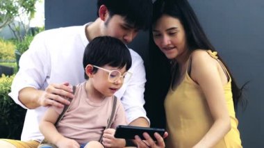 Mutlu bir aile. Anne ya da babasıyla cep telefonunda çizgi film izleyen tatlı bir çocuk ya da oğul. Harika bir aile filmi izliyoruz. Baba, anne sevgili çocuklarına öğretmenlik yapıyor ve onunla konuşuyorlar. Asya ailesi