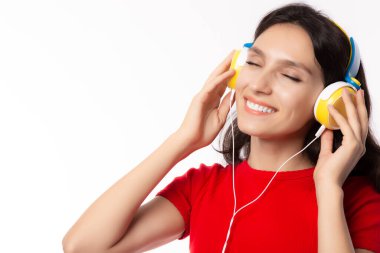 Güzel, beyaz bir kadın güzel müzikler dinleyip onu güldürüyor, mutlu ediyor. Çekici güzel kız müzik dinlemek için kulaklık kullanır. Çekici kadınlar rahatlar. beyaz arkaplanda izole
