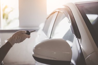 Tıbbi eldivenler. Kadınlar kovid 19, koronavirüs, grip virüsü ve mikropları korumak için koruyucu eldiven takarlar. Araba anahtarı ve uzaktan kumandayla araba açıyor. Virüse yakalandığını fark etti.