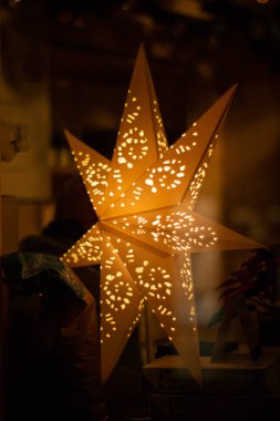 Büyük turuncu ışıklı dekoratif Noel yıldızı delinmiş incik kemiği.