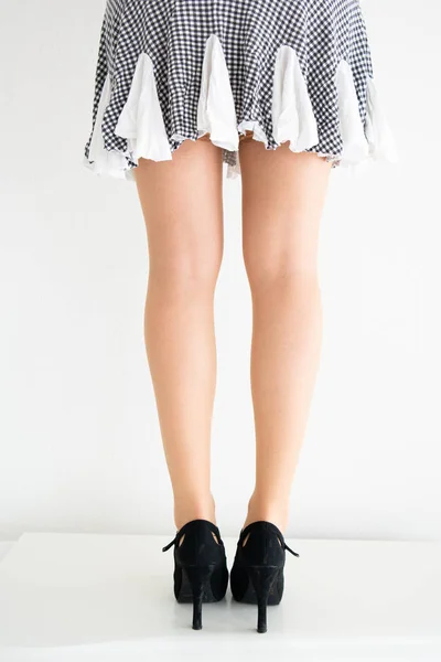 Joven caucásico piernas femeninas en medias, falda corta y negro — Foto de Stock