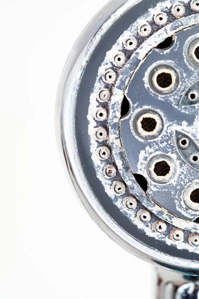 Gümüş yuvarlak duş başlığı ve her tarafında sert su birikintisi. 