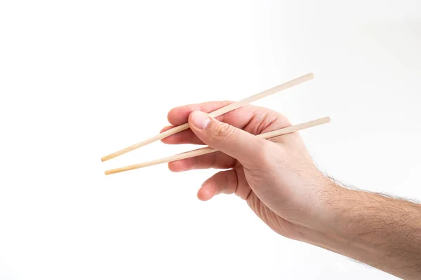 Ásia chop sticks realizada por caucasiano masculino mão close up tiro isol — Fotografia de Stock