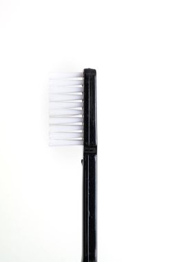 Simple new toothbrush with black plastic handle side view isolat