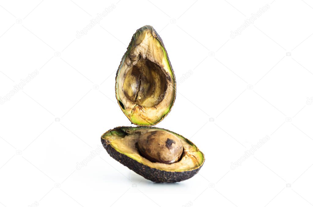 Halved rotten spoiled avocado fruit and seed macro close up shot isolated on pure white 2020