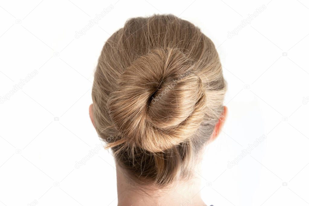 Simple bun hairstyle modeled by young white woman seen from behind close up shot isolated on white 2020