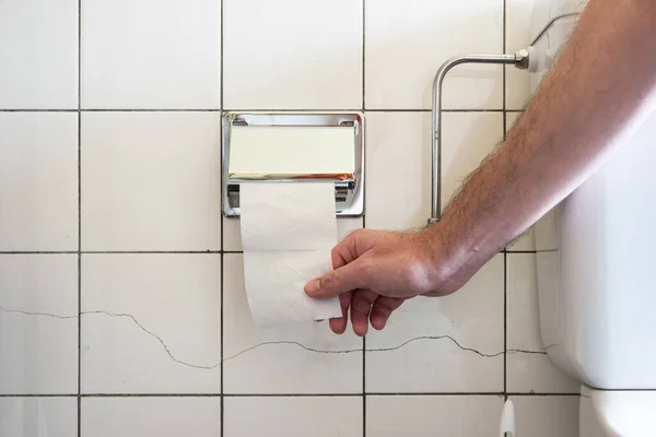 Kaukasische Männerhand Greift Nach Einer Fast Leeren Toilettenrolle Neben Einem — Stockfoto