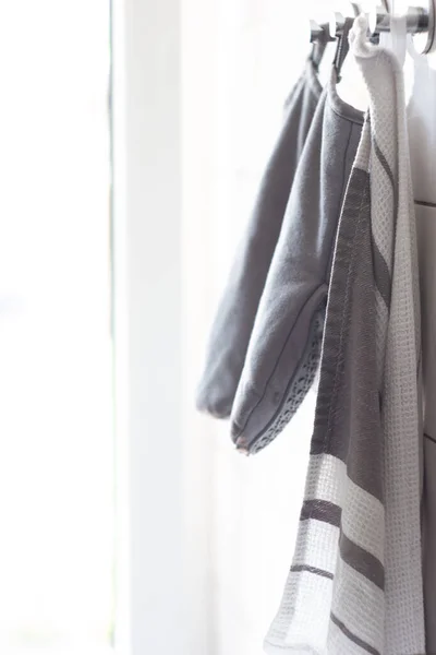 Keukenhanddoek Een Paar Ovenhandschoenen Hangend Aan Een Tegelwand Achterlicht Gedeukte — Stockfoto