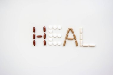 Şifa kelimesi, 2020 'nin beyaz arka planındaki farklı ilaç ve kapsüllerden türetilmiştir.