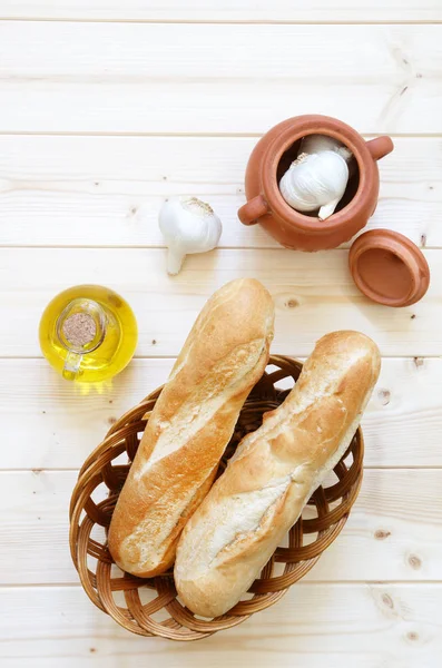 Rollos Pan Cesta Con Ajo Aceite Oliva Mesa Madera Clara Imagen de archivo