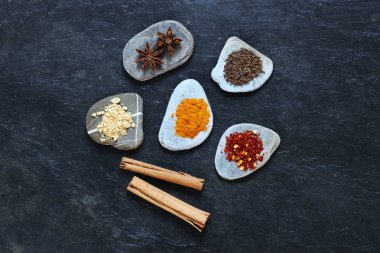 Tarçın ile merkezi grubunda çakıl taşları üzerinde renkli baharat sopa