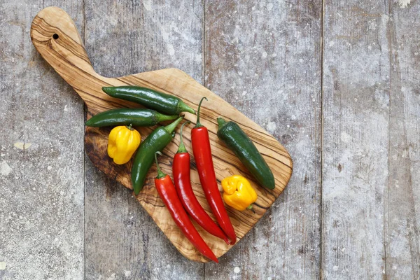 Red Green Yellow Hot Peppers Cutting Board Old Wooden Table — Stock Photo, Image
