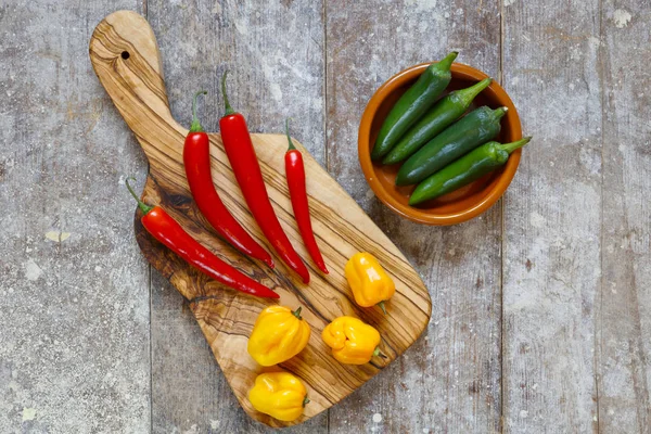 Red Yellow Hot Peppers Cutting Board Green Peppers Bowl Old — Stock Photo, Image