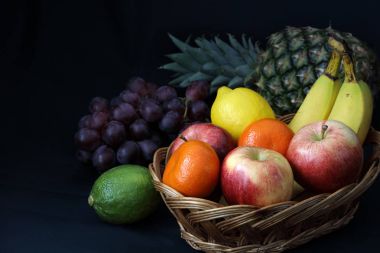 Karanlık gıda - ışık gölge koyu arka plan ile sepet içinde karışık meyve alan kalmadı kopyalama