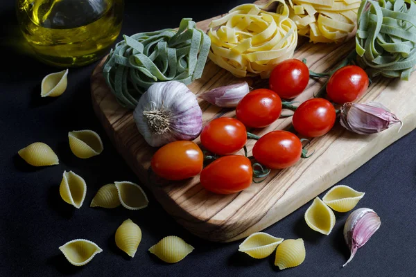 用意大利面条 面条和通心粉 Tricolore 和大蒜和带有复制空间的橄榄油关闭明暗对比深色食物面食配料 — 图库照片