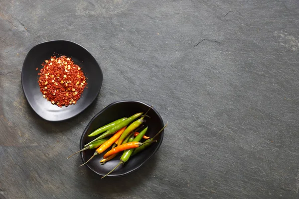 地面乾燥コピー スペースの黒い鉢に新鮮な唐辛子と唐辛子 — ストック写真
