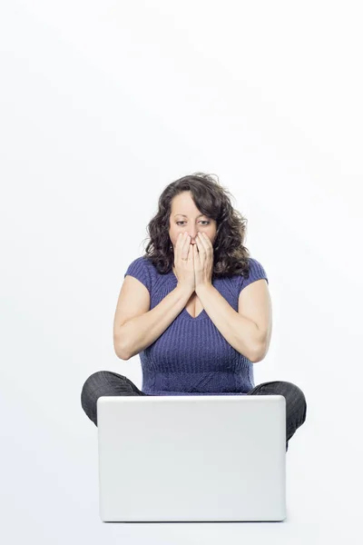 Bir dizüstü bilgisayar önünde sürpriz ifade ile genç bir kadın resim