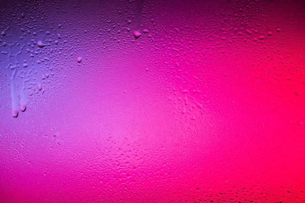Vidrio con gotas de agua sobre fondo colorido . — Foto de Stock
