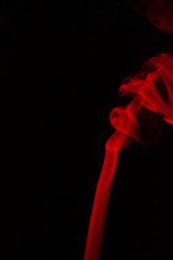 Siyah arkaplanda kırmızı dumanın soyut şekli.