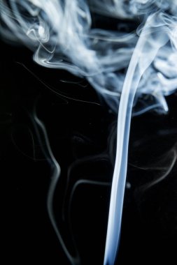 Siyah arkaplanda beyaz dumanın soyut şekli.