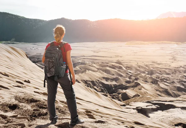 Kvinna med backpacker njuter av soluppgången på öken canyon. — Stockfoto