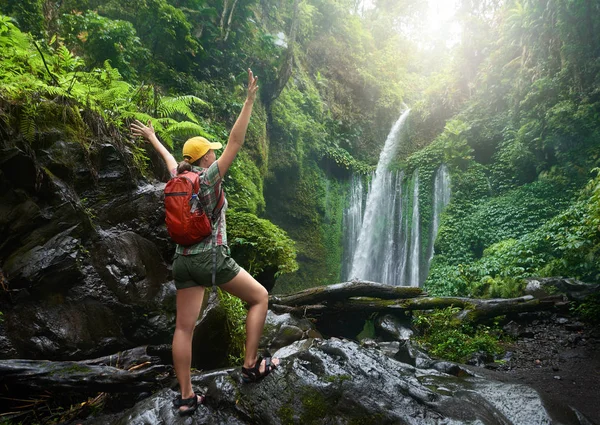 Junge Backpackerin genießt Aussicht am Wasserfall im Dschungel. — Stockfoto