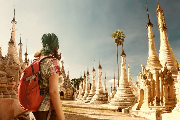 Mulher viajando com mochila e olha para stupas budistas — Fotografia de Stock