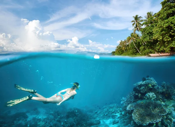 Frau schnorchelt in klaren tropischen Gewässern in der Nähe einer exotischen Insel — Stockfoto