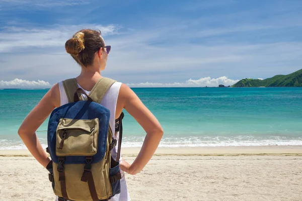 Tropikal bea çarpıcı manzarayı sırt çantası ile genç yolcusu — Stok fotoğraf