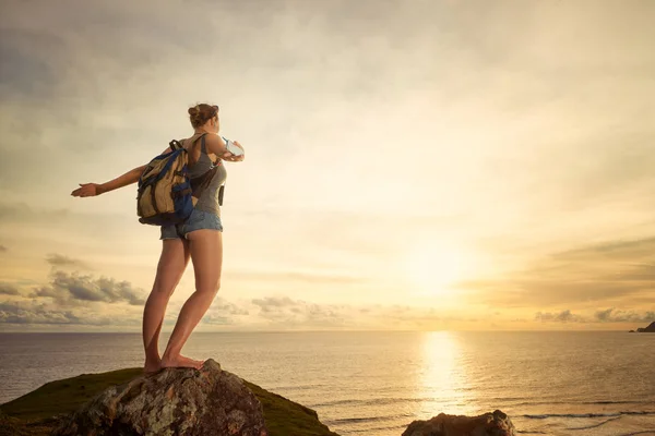Ξέγνοιαστες ευτυχισμένη γυναίκα ταξιδιώτη με σακίδιο, απολαμβάνοντας τη θέα στο ηλιοβασίλεμα — Φωτογραφία Αρχείου
