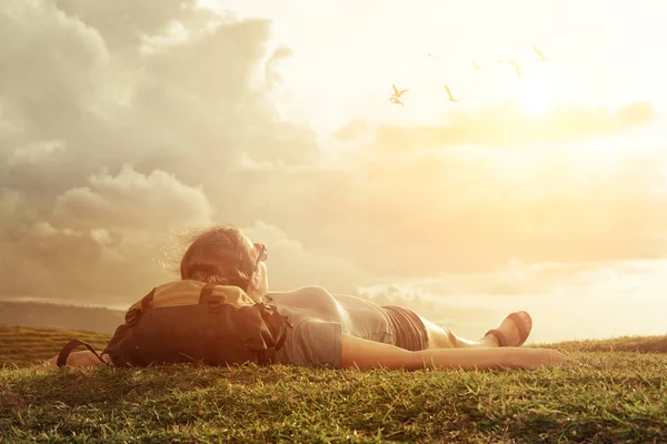 Viajero con mochila mirando al cielo y nubes sobre montañas — Foto de Stock