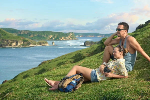 Pareja de excursionistas con mochilas disfrutando de la puesta de sol en la costa de montaña . — Foto de Stock