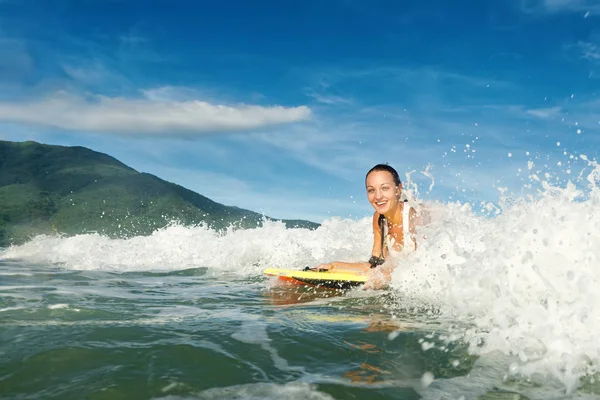 Hermosa joven morena nadando en la tabla de surf con una bonita sonrisa —  Fotos de Stock