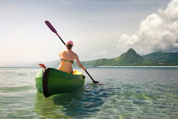 Viaggiatore donna esplorare la tranquilla spiaggia tropicale in canoa . — Foto Stock