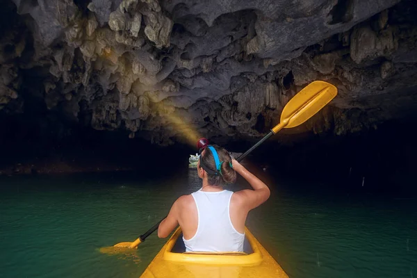 Kvinna som paddling kajak inne karst grotta — Stockfoto