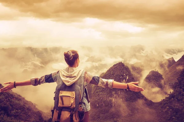 Wandelaar met rugzak in bergen genieten van uitzicht op de mistige berg — Stockfoto