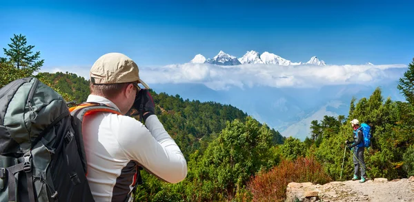 Vandrare med ryggsäckar ta bilder till bakgrunden av berg — Stockfoto