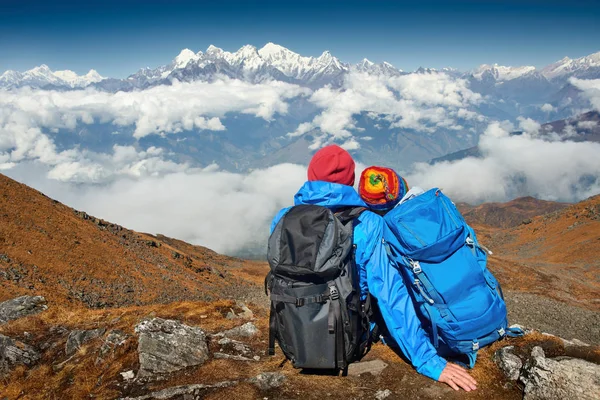 Caminhantes casal com mochilas olhando no topo da montanha — Fotografia de Stock