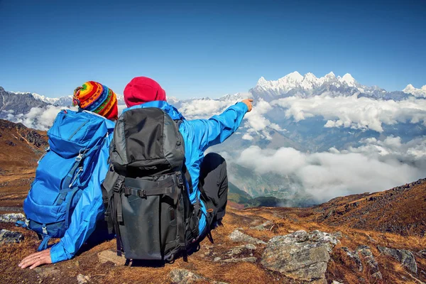Turisté s batohy, sedí na vrcholu hory, diskutovat — Stock fotografie