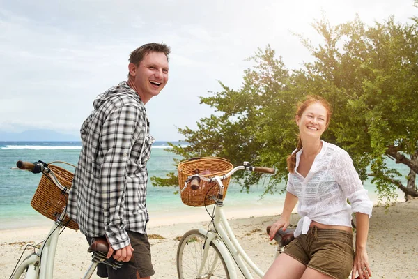 Portret tineri veseli care vorbesc și zâmbesc în timp ce stau lângă bicicletele lor de modă veche pe plajă . — Fotografie, imagine de stoc