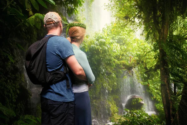 Joven pareja disfrutando de la compañía de unos a otros en selva tropical lookin —  Fotos de Stock