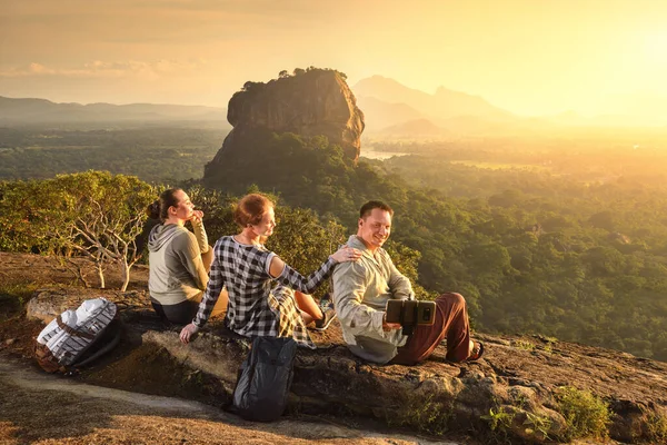 Gruppo giovani turisti si rilassa e guarda durante le vacanze colorato tramonto sullo sfondo del famoso altopiano roccioso picco del Leone, Sigiriya. Sri Lanka — Foto Stock