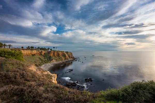 カリフォルニア州ランチョ パロス ヴェルデス Rancho Palos Verdes の岩の海岸線では 空のカラフルな雲と穏やかな波が洗濯され 日没時にポイントビセンテ灯台の豪華な長い露出の崖の上の景色 — ストック写真