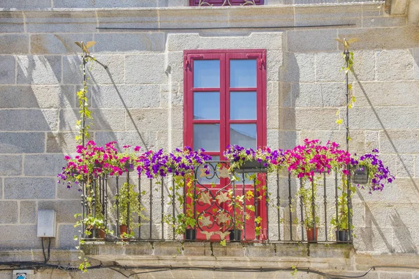 Balcone fiorito e porta rossa — Foto Stock