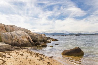 Kıyı kayalar ve cirrus bulutlar