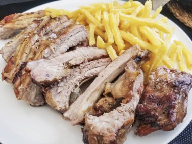 Izgara domuz kaburgası ve kızarmış patates.