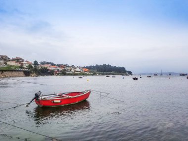 Arousa Adası 'ndaki Donanma balıkçı limanında demirli kırmızı tekne.